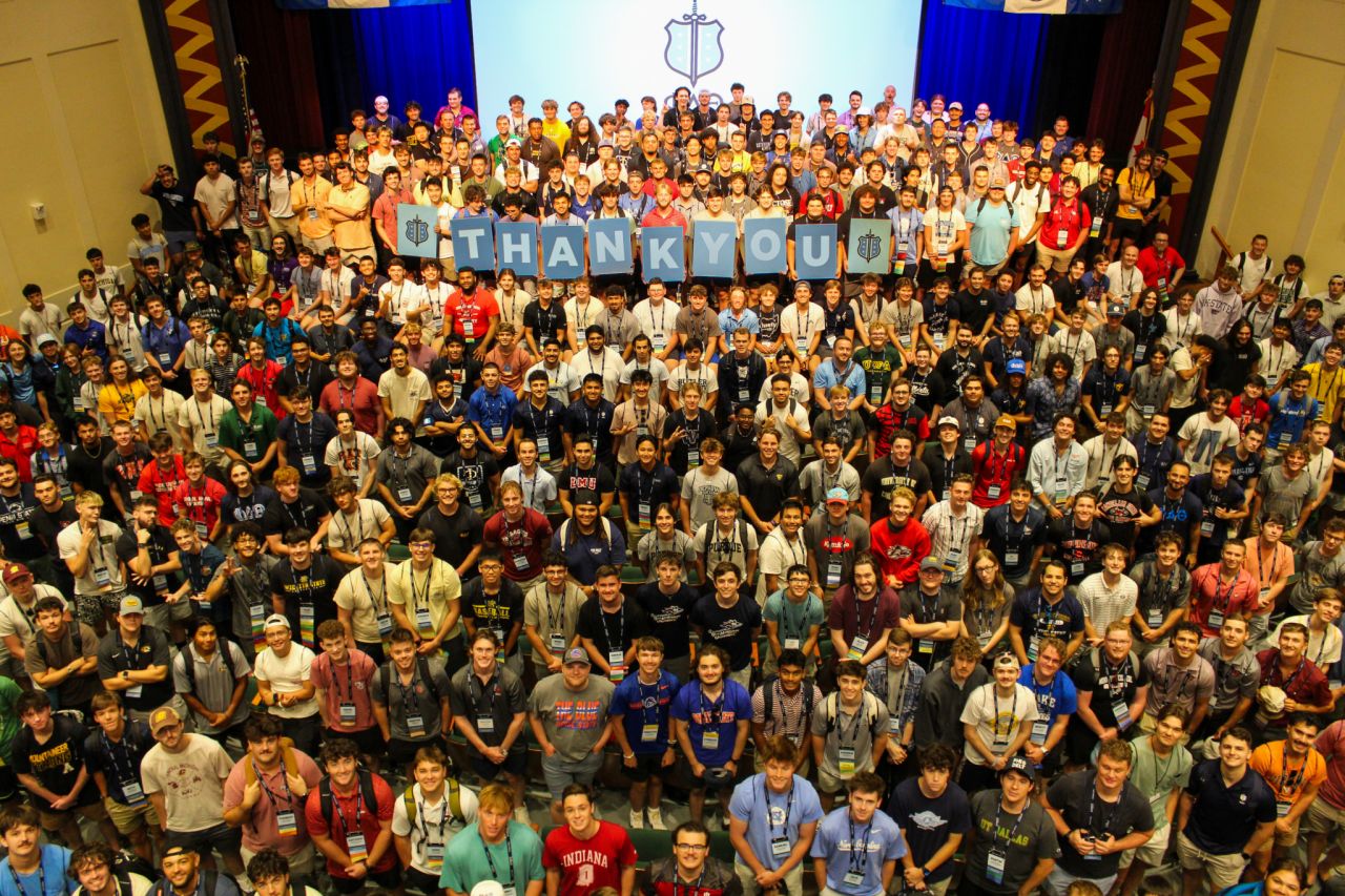 The group of Phis at the conference holding a thank you sign